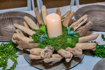 Wedding day table decoration with candle, moss and wood sticks  on wooden tables