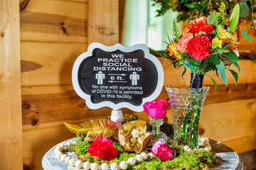 Wedding Day: Table with flowers and a Covid-19 Sign