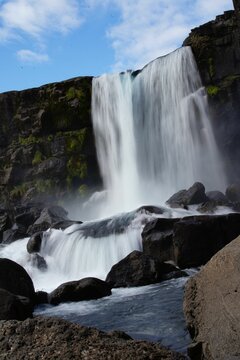 Low angle shot of a waterfall cascading over rocks