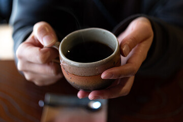 温かいコーヒーを飲む