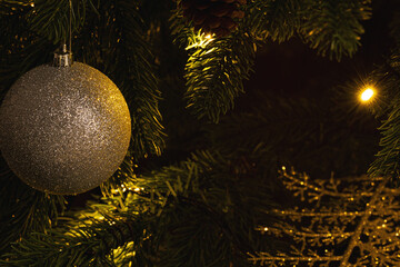 Beautiful green Christmas tree decorated with balls and garlands. Close-up photo. Sparkling background.