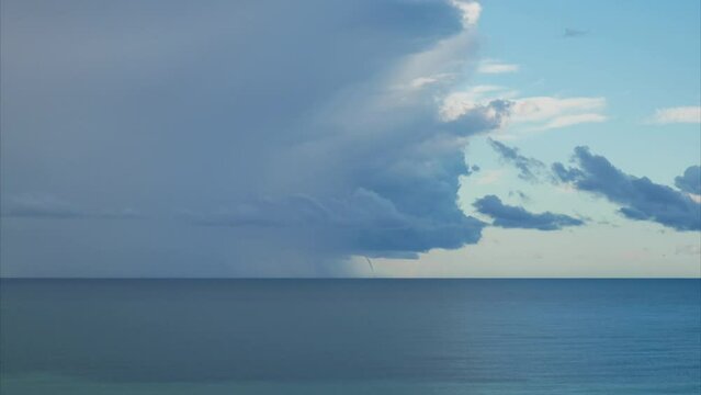 Timelapse. Clouds swirl into a funnel, a small tornado is formed