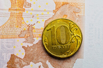 RUR golden coin lying over Euro banknote depicting raise of Russian economics ander sunctions and raise of inflation in EU - 549408167