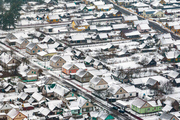 aerial panoramic winter view of village with houses, barns and gravel road with snow