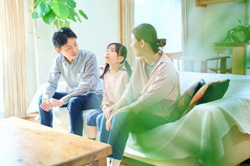 Obraz premium リビングルームで楽しそうに話す親子3人