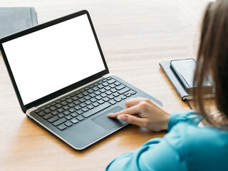 Distance education. Computer mockup. Digital technology. Unrecognizable woman typing laptop blank screen sitting desk light room interior.