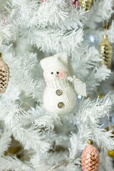 Christmas decorations. A snowman figurine on a white Christmas tree.