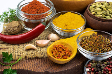Assortment of spices on a wooden board in close-up.