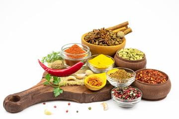 Assortment of spices on a cutting board isolated on a white background.