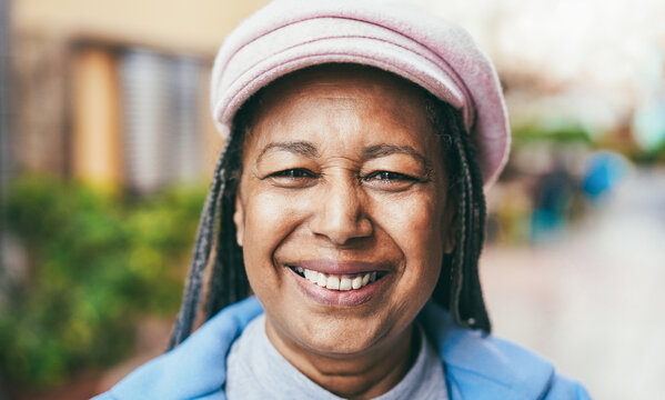 Happy african senior woman smiling on camera outdoor during winter day - Focus on face