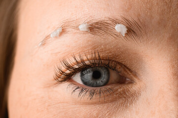 Fototapeta na wymiar close-up of female eye and eyebrow with white foam on it