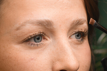 Close-up view of professional lamination procedures of female eyebrows in beauty salon.