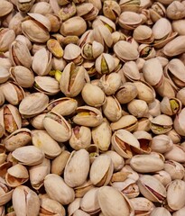 Fondo con detalle y textura de multitud de pistachos tostados con cascara y tonos marrones y verdes