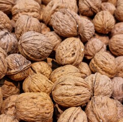 Fondo con detalle y textura de multitud de nueces con cascara y tonos marrones