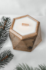 Decorative scented candles in a pot and fir branches, festive composition, selective focus