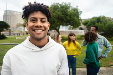 Smiling hispanic latin young man looking at camera outdoors. Portrait of african american...