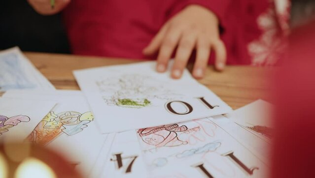 Little girl draw a picture for santa in New Year in the room. High angle close up of little girl drawing Christmas cards and decorations in school, copy space