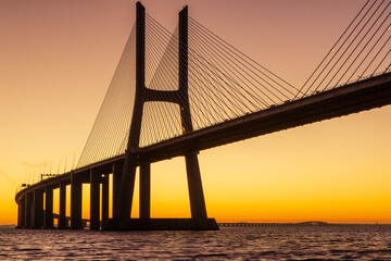 Fototapeta na wymiar Vasco da Gama bridge at sunrise in a cold November morning: this bridge is simply beautiful, curvy and sexy!