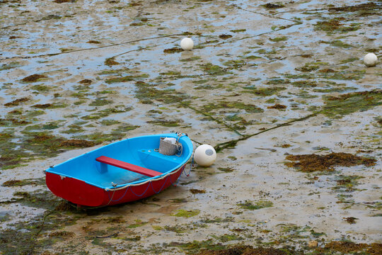 Dinghy fallen dry at low tide in the harbor of Roscoff, Brittany, France