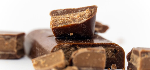 filled chocolate bar. Broken pieces over white background