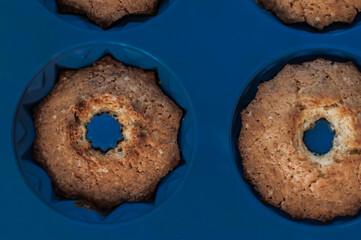 Baked pumpkin muffins in blue silicone baking dish closeup.