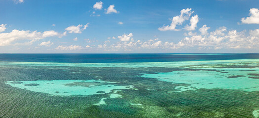 Turquoise lagoon surface on atoll and coral reef, copy space for text. Panoramic view transparent turquoise ocean water surface, background texture