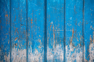 Old door aged by time made of natural wood painted in intense blue