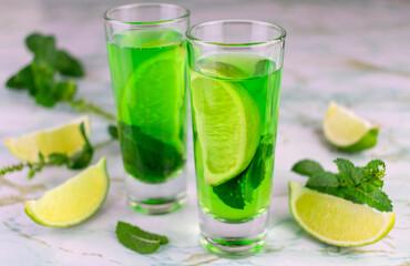Delicious mint liquor with lime and green mint leaves, closeup
