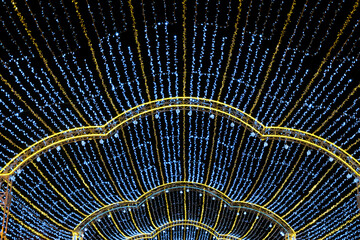 Lights of tent overhead garlands. New year illuminated decorations.