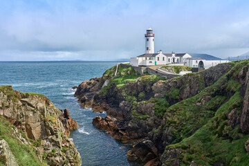 Fototapeta na wymiar Fanad Head Lighthouse with its rough cliffs in the northern part of Republik of Ireland