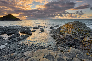 Irish coastline with Volcanic hexagonal basalt columns of Giant`s Causeway at sunset in Northern...