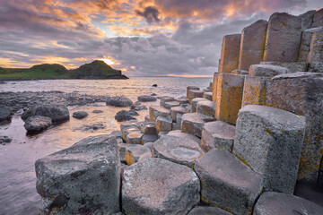Irish coastline with Volcanic hexagonal basalt columns of Giant`s Causeway at sunset in Northern...