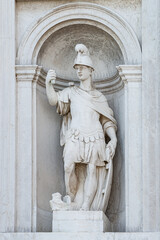 Obraz premium Old sculpture of a Roman soldier in armor, in downtown of Venice, Italy, closeup, details.
