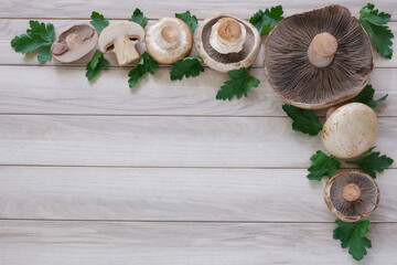 Whole and cut Agaricus mushrooms lie on the table. Mushrooms of different sizes. Background. A place for your text. High quality photo