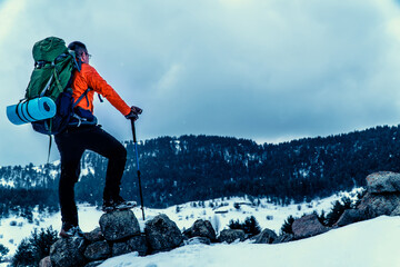 backpacker camper man walking in mountains in winter