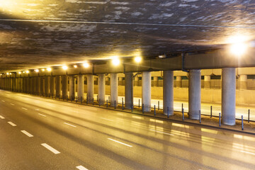 Fototapeta na wymiar Tunnel background. Road under the bridge. Empty asphalt road. Metro road passage. Grunge urban landscape. Underground way.