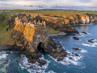 Aerial view with Dunluce Castle, the famous fortress in ruin in Northern Ireland UK, seen at sunrise