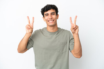 Young Argentinian man isolated on white background showing victory sign with both hands