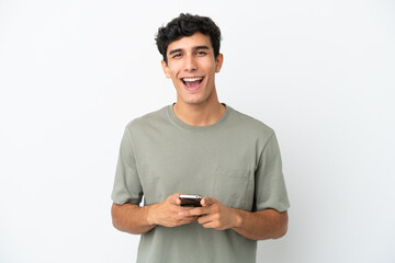 Young Argentinian man isolated on white background surprised and sending a message
