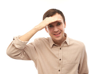 Caucasian young male in casual looks future, looking far away distance with hand over head isolated on white background. Search concept.