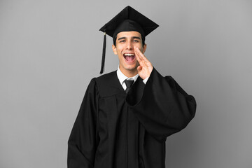 Young Argentinian university graduate isolated on grey background shouting with mouth wide open