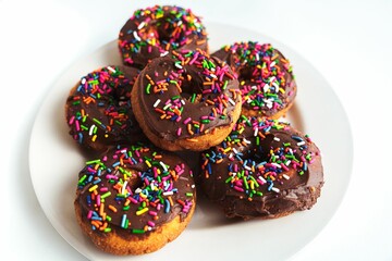 Top view closeup of chocolate covered donuts with colorful sprinkles
