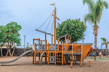 Puerto de la Cruz, Spain - November 25,2021: Wooden slide in the children park Parque Infantil de Playa Jardin in Puerto de la Cruz, Tenerife. Place of active recreation for kids in the Canary Islands