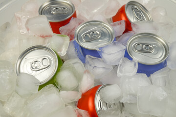 Cooling and storing aluminum cans with beverages in the pieces of ice. Cans of soft drink in the ice
