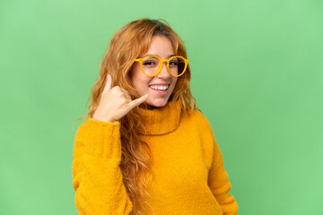 Fototapeta premium Young caucasian woman isolated on green screen chroma key background With glasses and doing phone gesture