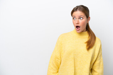 Young caucasian woman isolated on white background doing surprise gesture while looking to the side