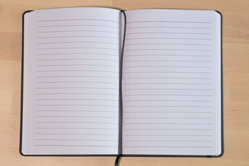 Empty lined notebook on wooden table. Ruled paper notebook