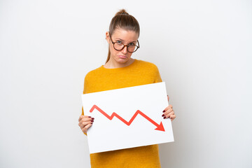 Young caucasian woman isolated on white background holding a sign with a decreasing statistics arrow symbol with sad expression