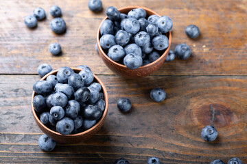 Freshly picked blueberries in  bowl. Bilberry on wooden Background. Blueberry antioxidant. Concept for healthy eating and nutrition