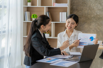 Two young asian accountants working on laptop computer and finance at workplace. Freelance business. Online marketing. ecommerce marketing ideas